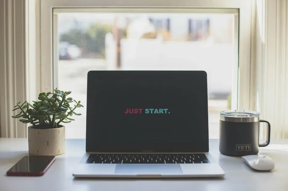 Open laptop with the words ‘Just Start’ displayed on the screen